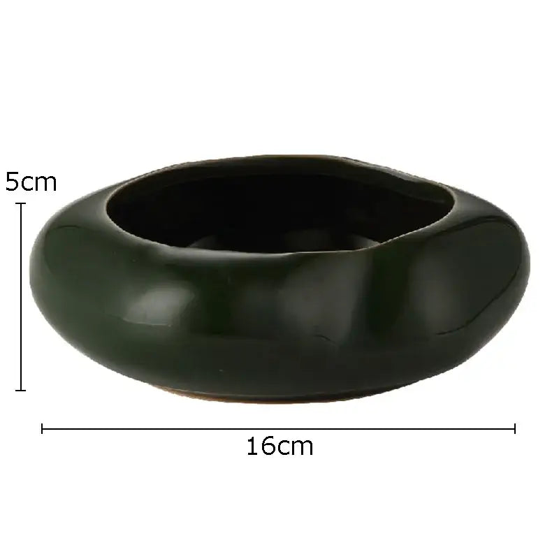 A smooth glossy dark green lotus seedpod ceramic incense burner with rounded organic shape for living room decor