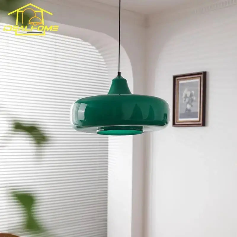 A sleek glossy emerald green glass pendant light with a modern rounded design for dining room use