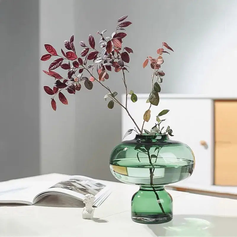 A translucent emerald green glass green gourd vase with a rounded body and pedestal base for living room decor
