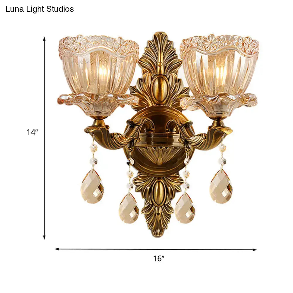 Modern floral brass wall sconce with gold-toned finish amber glass shades and teardrop crystal drop for living room