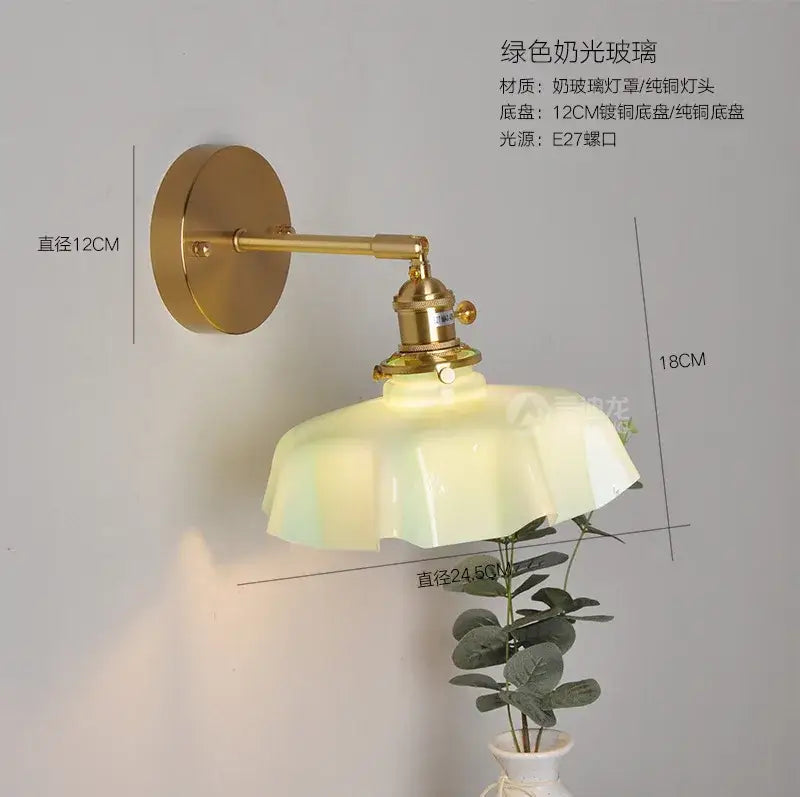 Green frosted glass wall sconce with brass metal arm complements modern fluted glass pendant lights for dining room