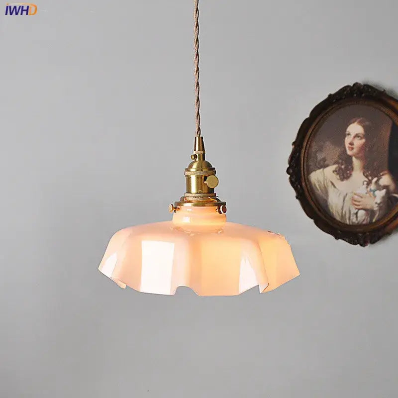 Vintage-style pendant light with warm translucent peach glass shade and brass hardware ideal for dining room lighting