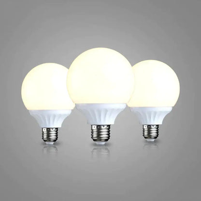 Three illuminated frosted white e27 9w led bulbs with metallic bases high brightness round lamps for bedroom use