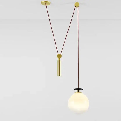 Gold-toned pendant light with spherical frosted glass shade and brass hardware for modern dining rooms chandelier
