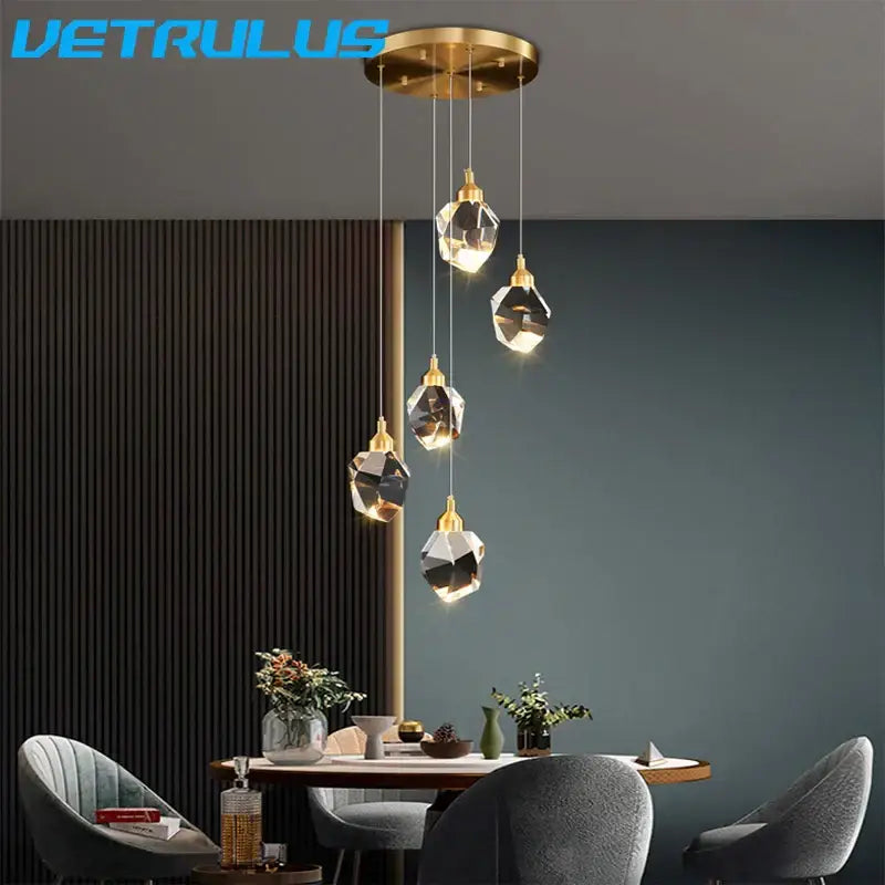 Gold-toned modern geometric brass pendant light with five faceted diamond crystal led shades for dining room chandelier
