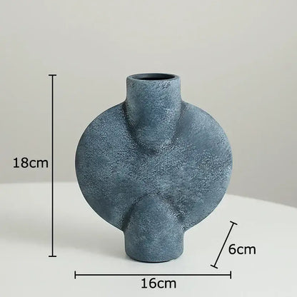 A matte blue geometric ceramic vase with textured asymmetrical design and rounded contours for decorbites geometric decor