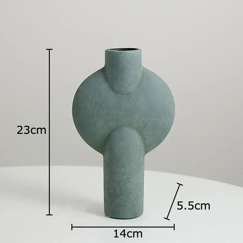 A matte sage green decorbites geometric ceramic vase with rounded curves and textured surface for living room decor