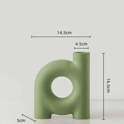 A sleek matte sage green decorbites geometric ceramic vase with a central circular cutout and two short legs for decor