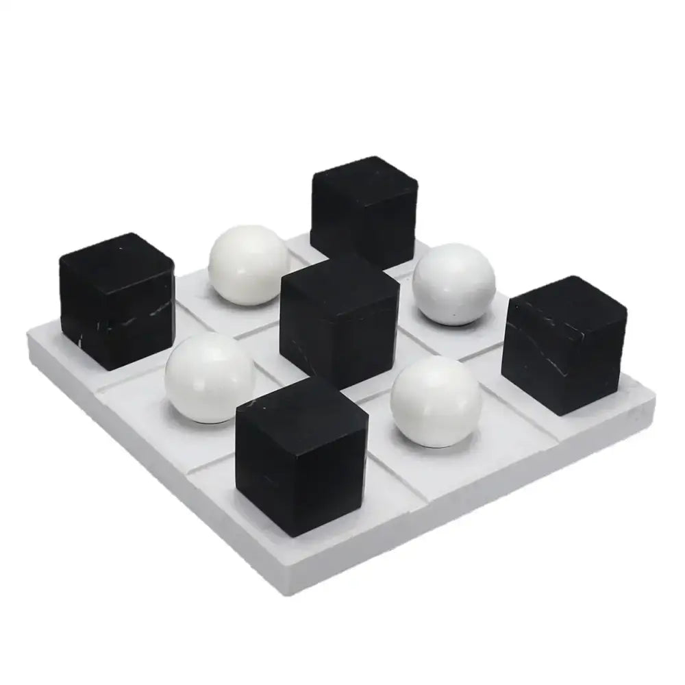 Modern geometric chess ornament set with black and white glossy cubes and spheres on gray grid base for home decor