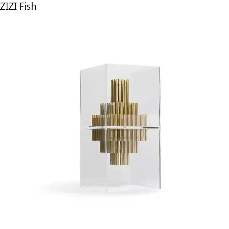 A modern geometric display box featuring golden brass rods in a transparent acrylic case for living room decor