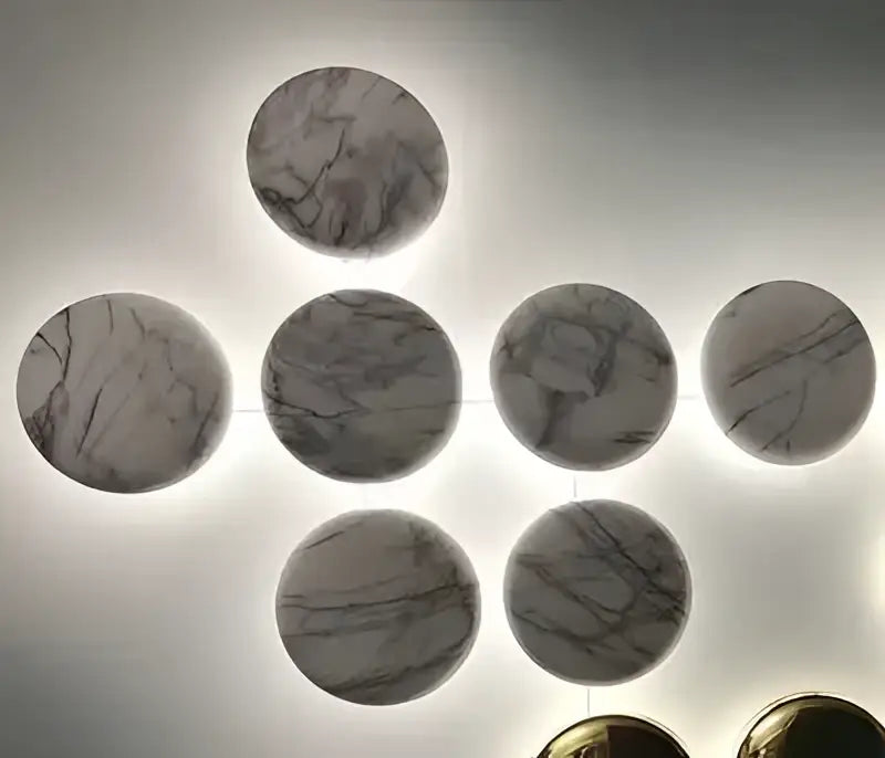 Modern geometric glossy gold led wall sconces featuring circular marble wall art with gray and white veining in geometric pattern