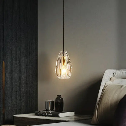 A modern geometric gold and clear crystal led ceiling chandelier with a warm glow suspended by a black cord decorbites crystal led