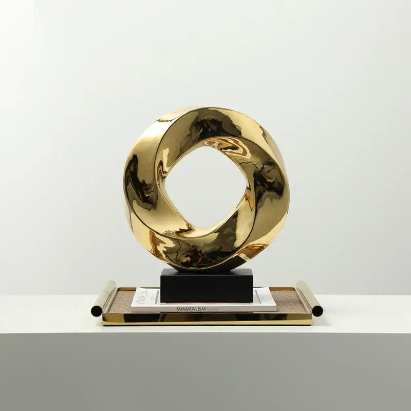 Shiny gold metallic geometric gold hollowed sculpture with twisted interlocking rings for modern home decor