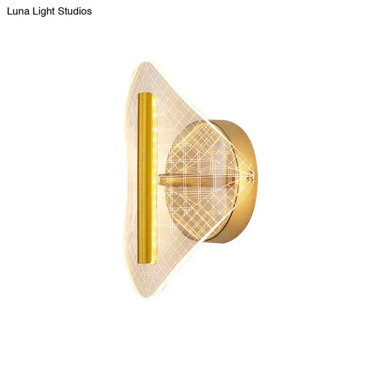 Modern geometric gold sconce light with a sleek angular design and illuminated grid pattern diffuser for living room use