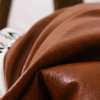 Modern geometric white and black cushion cover with rich brown decorbites brown faux leather textured surface and tassels