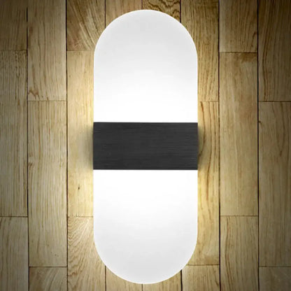 Modern oval-shaped wall sconce with frosted white diffuser and matte black accent band for bedroom wall lamp lighting