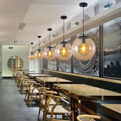 Modern glass ball led pendant lights with warm-toned spherical glass and black metal fixtures for dining room decorbites decor