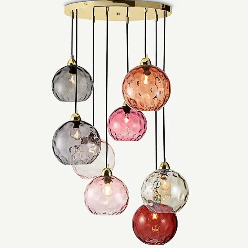 Modern pendant lights featuring seven textured decorbites glass ball globes in pink red gray and clear on brass mount
