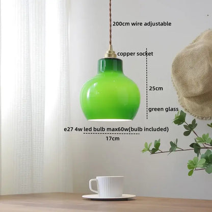 A vibrant green glass copper pendant light with copper socket and braided wire for dining room or kitchen island