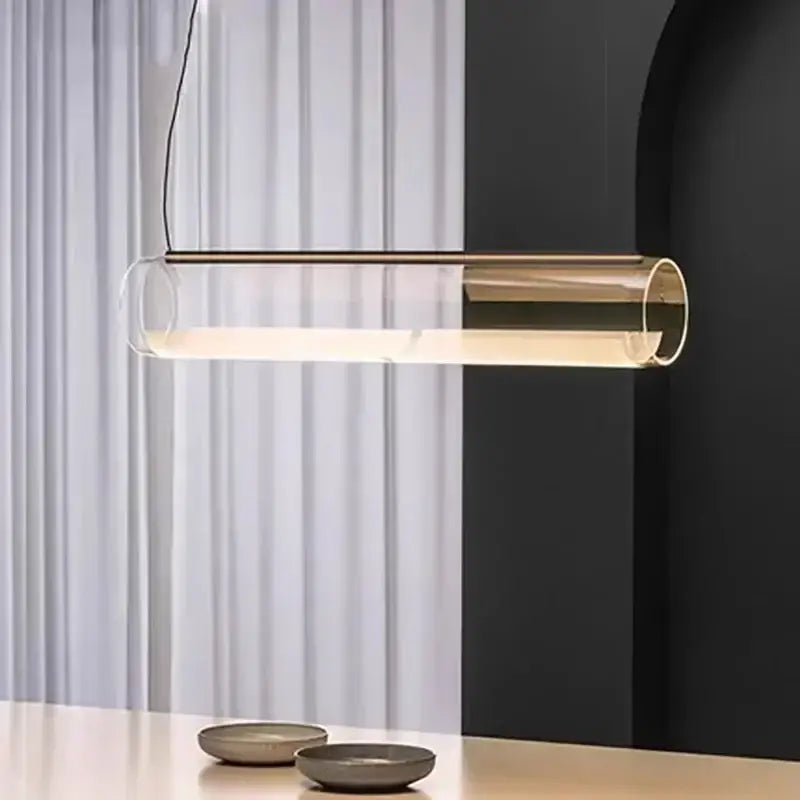 Modern glass cylinder chandelier with clear glass body and gold-toned accents emitting warm ambient lighting decorbites glass cylinder
