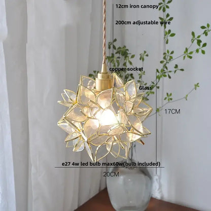 A delicate gold-toned glass flower led pendant light with a starburst design for modern dining room use