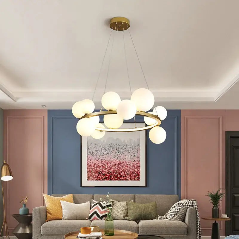 Modern gold-toned glass chandelier lamp with frosted glass globe lights in circular arrangement for kitchen island lighting