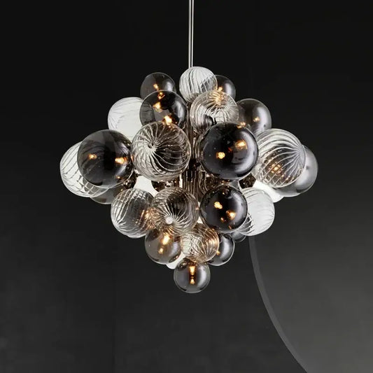 A modern glass globe led chandelier with clear and dark ribbed glass spheres suspended by a sleek metallic rod