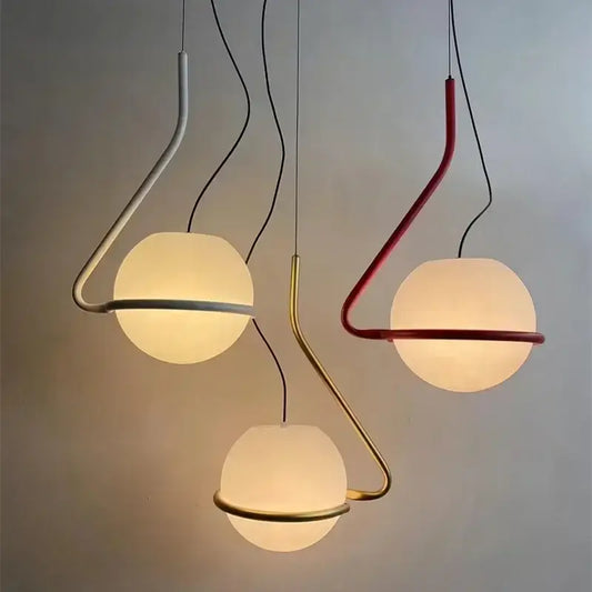 Three modern pendant lamps with frosted glass globe shades and curved metal frames in white red and gold for kitchen island decorbites glass globe pendant
