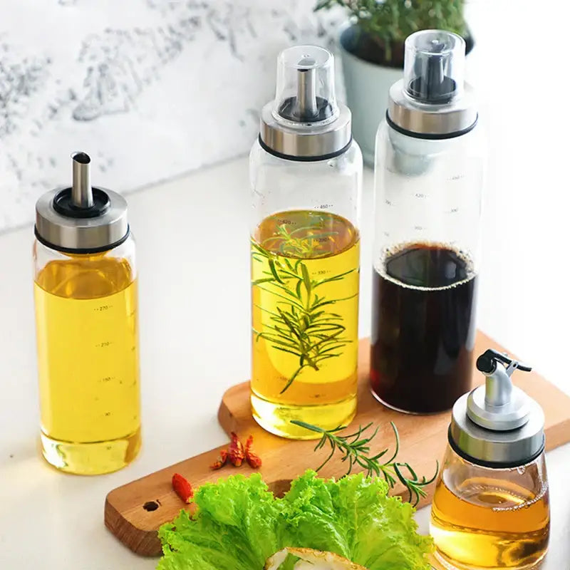 Modern glass seasoning storage bottle set with clear glass dispensers and stainless steel pumps for kitchen organization
