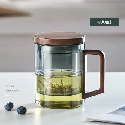 Modern decorbites glass tea cup with wooden lid and handle filled with amber green tea leaves for kitchen drinking