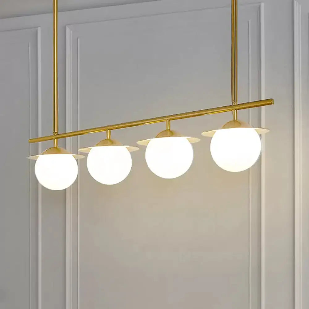 Decorbites gold opal glass round island pendant light with four frosted glass globes in a gold-toned contemporary round island design