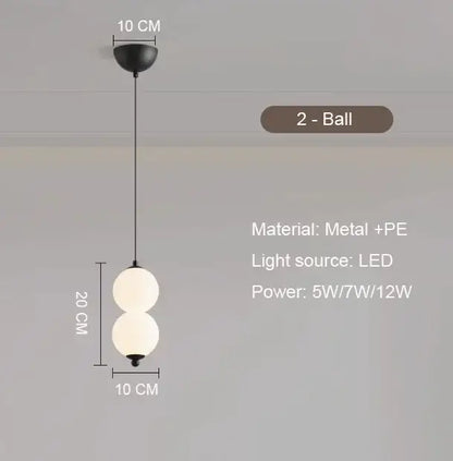 Black metal pendant light with plated gold-toned surface and two white spherical glass balls as dining room focal point