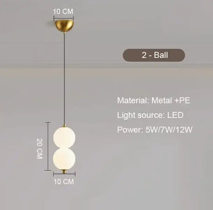 Modern pendant light with plated gold-toned surface and two frosted glass spheres as a dining room focal point