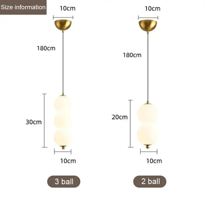 Modern gold pendant light with plated gold-toned surface and frosted glass spheres as a dining room focal point