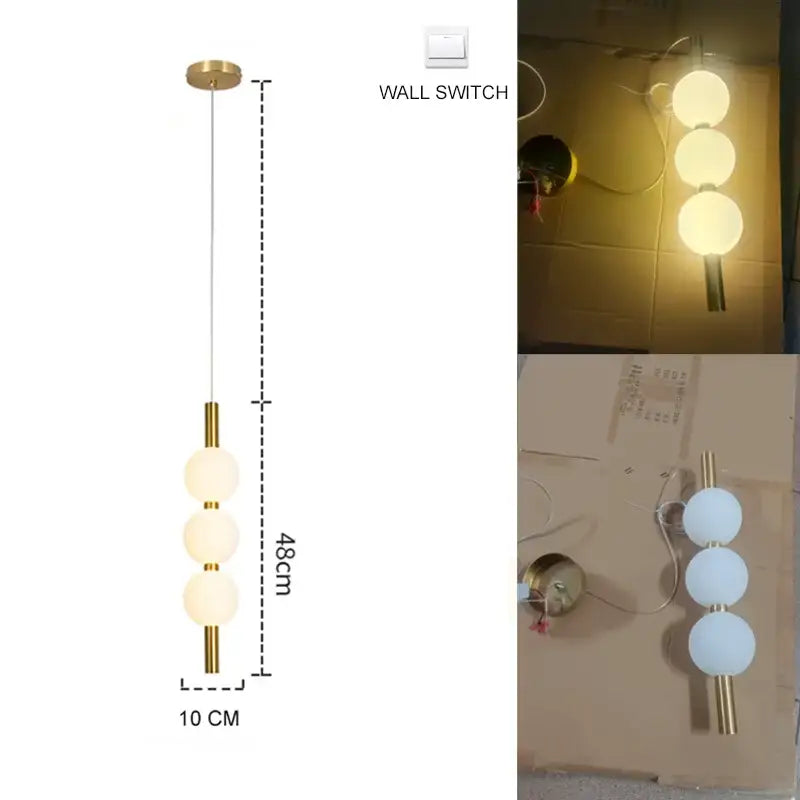 Modern gold pendant light with plated gold-toned surface and three frosted glass spheres as a dining room focal point