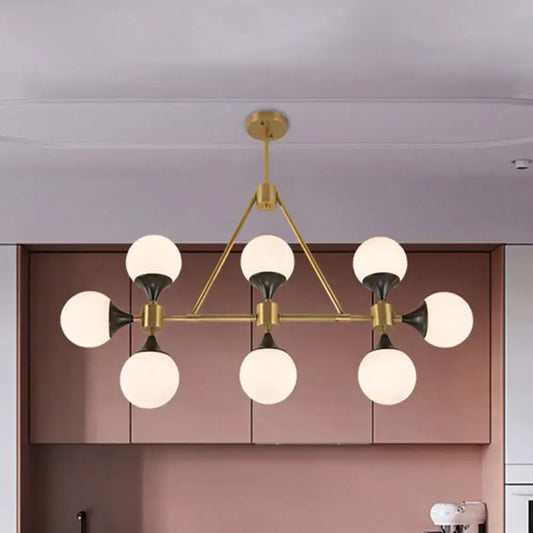 Modern gold decorbites metal chandelier with six frosted glass globe shades and black accents for island lighting