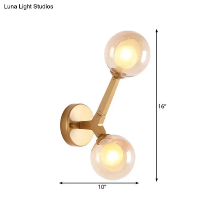 Modern gold amber glass wall light fixture with two spherical shades for bedroom accent lighting