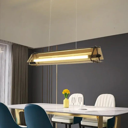 Modern gold amber led pendant lamp with a sleek rectangular design hanging above dining table decorbites amber led