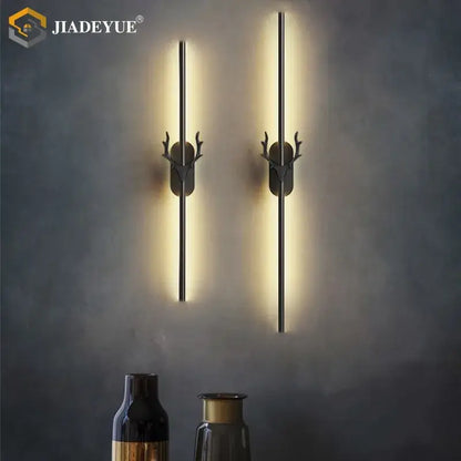 Pair of modern black metal wall lamps with gold decorbites deer horn accents and warm deer horn led lighting