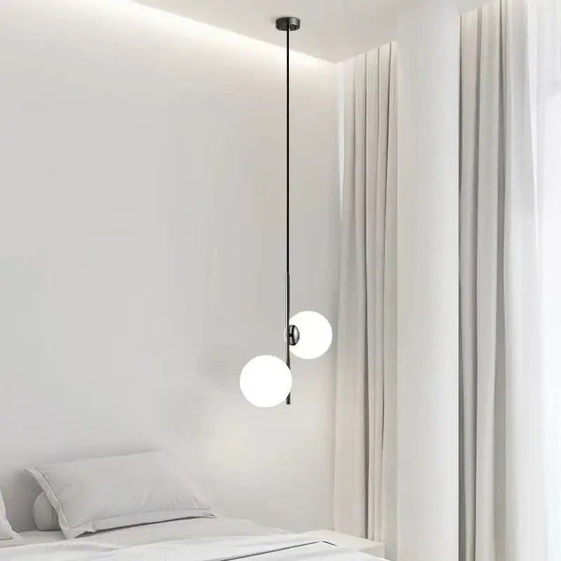 Modern gold and black glass ball led pendant light with two frosted glass spheres suspended by black metal rod