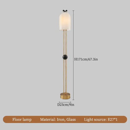 A tall slender floor lamp with brass metal frame and off-white glass shade complementing a modern glass led chandelier
