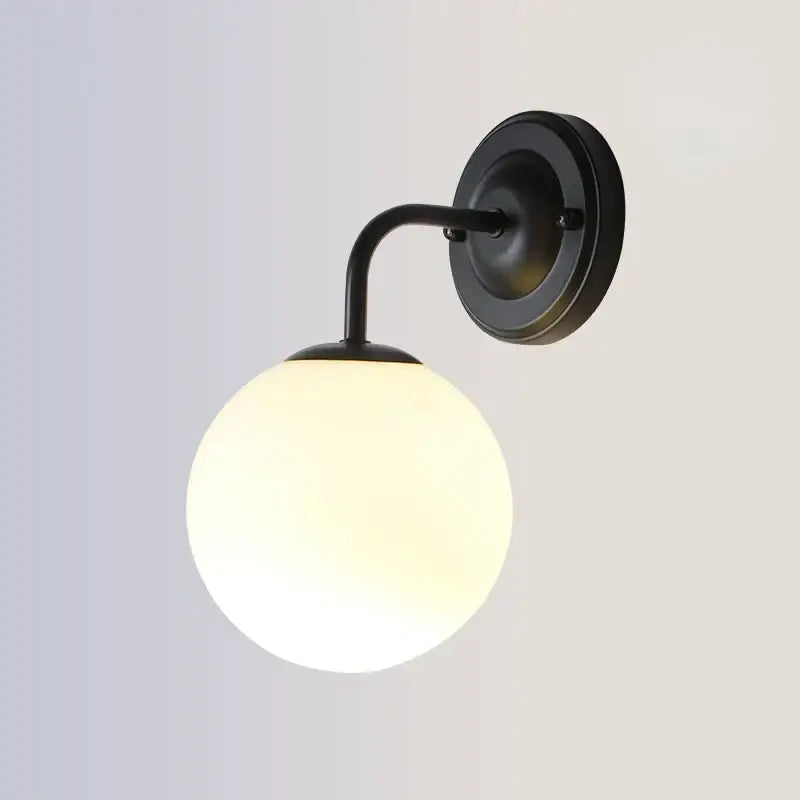 Modern gold and black led glass ball wall lights featuring a black wrought iron sconce with frosted glass globe by decorbites brozen black led