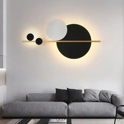 Modern gold and black led wall lamp featuring a sleek bar with three circular shades emitting warm ambient light