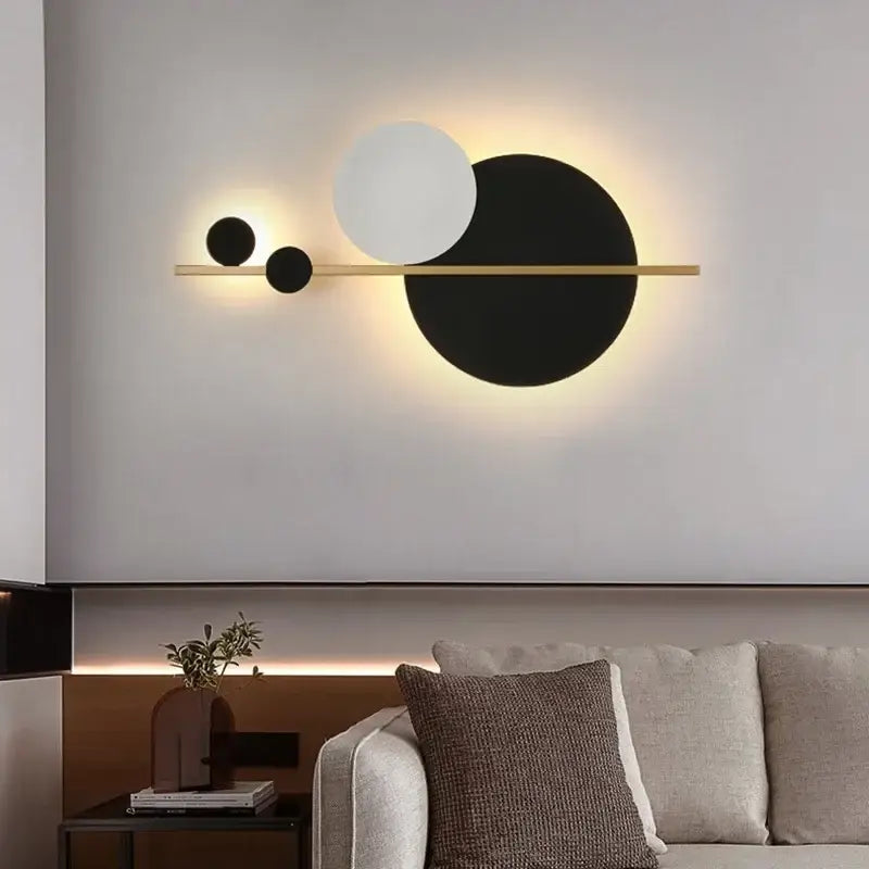 Modern gold and black led wall lamp with three circular shades on a slender horizontal bar for bedroom sconce lighting