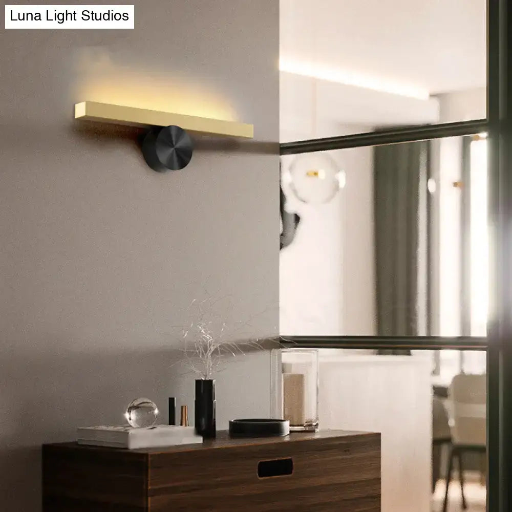 Modern gold and black linear wall light fixture with brushed gold sconce and black base emitting warm light 110v-120v
