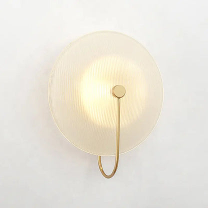 Modern gold and black wall lamp with circular textured frosted glass shade and minimalist metal arm for living rooms