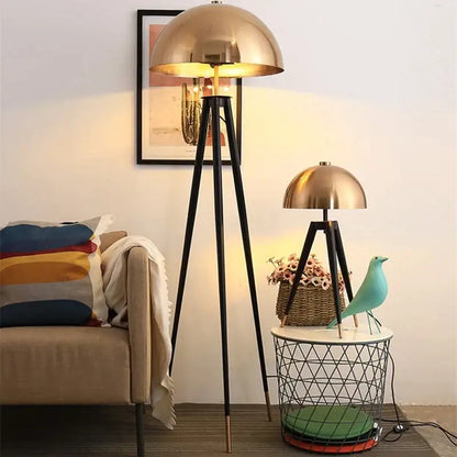 Modern gold and black decorbites coyote tripod floor lamp with brass dome and warm glowing light for living room decor