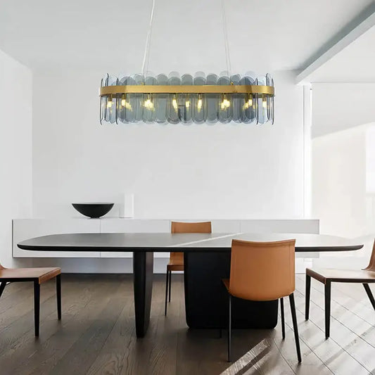 Modern glass chandelier with gold-toned metal frame and blue glass panels enhancing the dining experience lighting solution