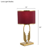 DecorBites™ red fabric drum nightstand lamp with a gold-toned base and textured burgundy shade for bedside lighting