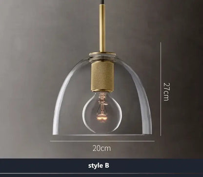 Modern gold and clear glass led pendant light with brass accents and exposed bulb for dining room use